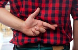man crosses finger behind his back