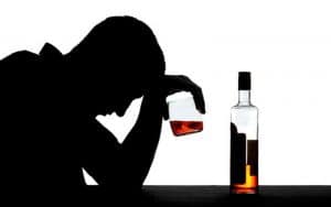 man sitting and drinking alcohol by himself