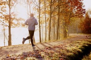 a man jogging in early morning by the lake