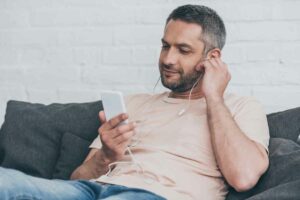 A man is listening to addiction podcast to get some insights for the recovery tools