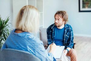 Depressed male patient having psychotherapy session with a counsellor. comfortable depression
