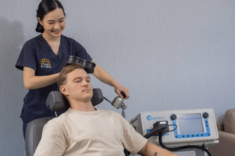 A female nurse doing TMS therapy to a male client.